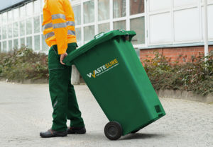 Male Worker Walking With Dustbin On Street