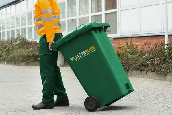 Male Worker Walking With Dustbin On Street