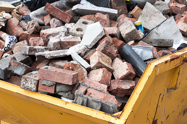 Yellow metal skip full of old bricks