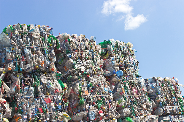 Stack of plastic bottles for recycling against blue sky