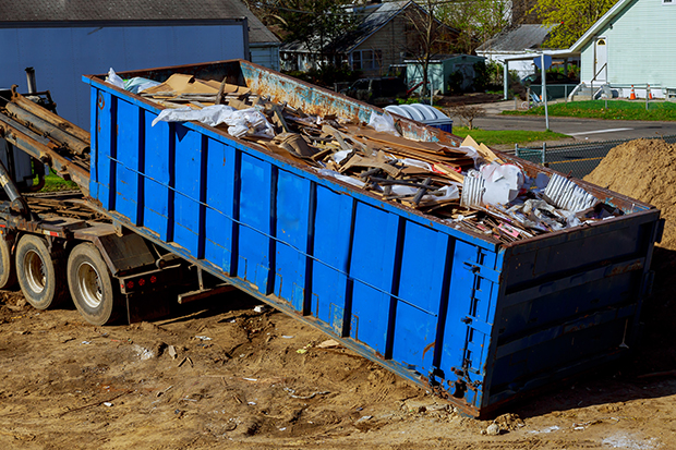 Truck loading a recycling garbage full skip waste management container